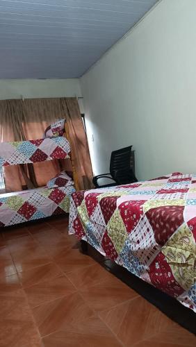 a bedroom with two beds with quilts on them at Hospedaje Encarnacion in Encarnación