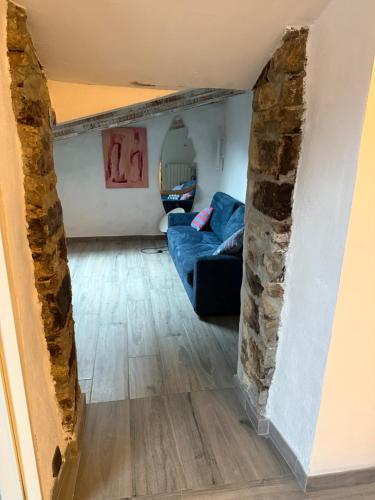 a living room with a blue couch and a stone wall at casa vacanza serena in Palazzago