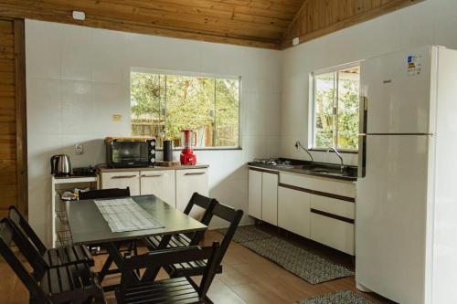 a kitchen with a table and a refrigerator at Na Casa da Ilha in Paranaguá