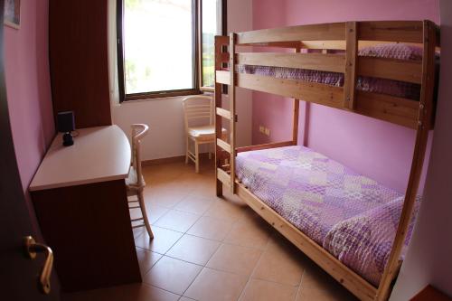 Zimmer mit Etagenbett, 2 Etagenbetten und einem Schreibtisch in der Unterkunft Appartamenti Fiorella in Bastia Umbra