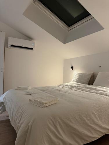 a bedroom with a large white bed with towels on it at Il Clovio - Discreet luxury, close to Futuroscope in Jaunay-Marigny