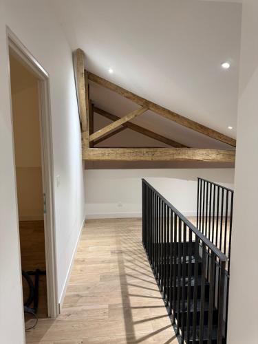a room with a staircase with wooden beams on the ceiling at Il Clovio - Discreet luxury, close to Futuroscope in Jaunay-Marigny