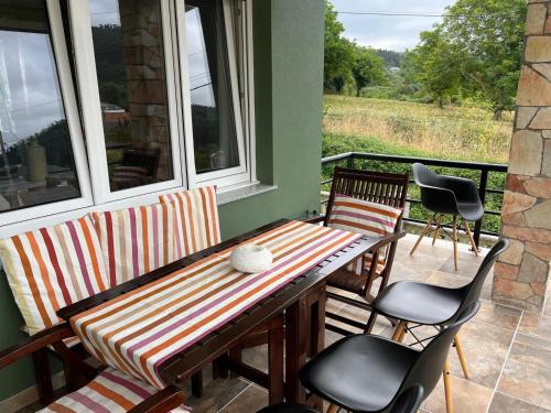 a porch with a table and chairs on a balcony at Casa do Olmo in Porto de Espasante