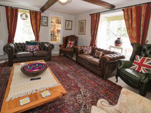 a living room with leather couches and a table at Bryn Dwr in Llangollen