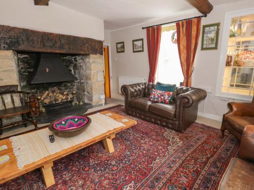 a living room with a couch and a fireplace at Bryn Dwr in Llangollen
