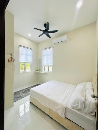 a bedroom with a bed and a ceiling fan at Laman Kota Pool Homestay in Kota Sarang Semut
