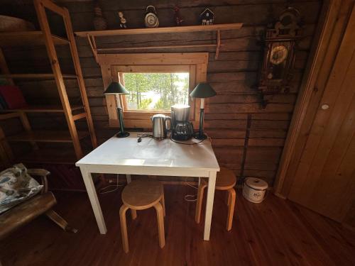 a table with a coffee maker on it in a cabin at Saimaa Lakeside Sauna Cabin in Taipalsaari