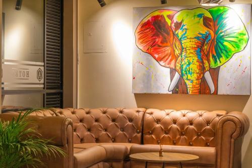 a couch in a living room with a painting of an elephant at HOTEl AIRPORT PEREIRA in Pereira