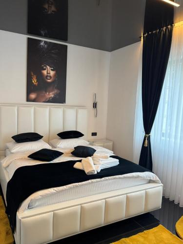 a bedroom with a large white bed with black pillows at HERA Elysium Apartament AFRODITA in Sinaia