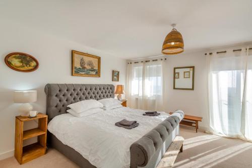 a bedroom with a large bed with a gray headboard at Sunset Townhouse – Pwllheli in Pwllheli