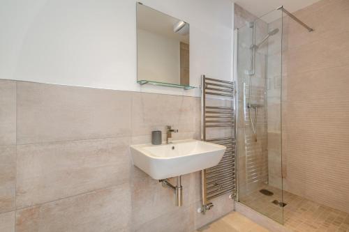 a bathroom with a sink and a shower at Sunset Townhouse – Pwllheli in Pwllheli