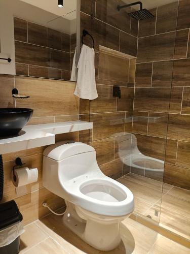 a bathroom with a toilet and a glass shower at HOTEl AIRPORT PEREIRA in Pereira