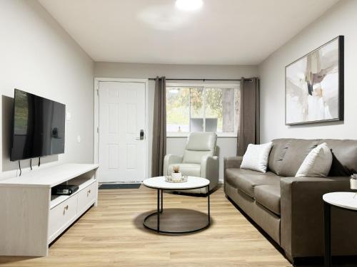 a living room with a couch and a tv at Cozy Retreat - Homes near Wesselman Park in Evansville