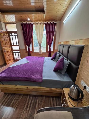 a bedroom with a large bed with purple sheets at The Solace Hills Hotel and Home Stay - Manali in Manāli