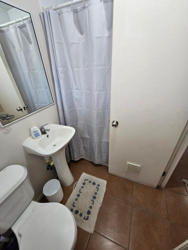 a bathroom with a white toilet and a sink at Departamento diario en Copiapo en quinto piso in Copiapó