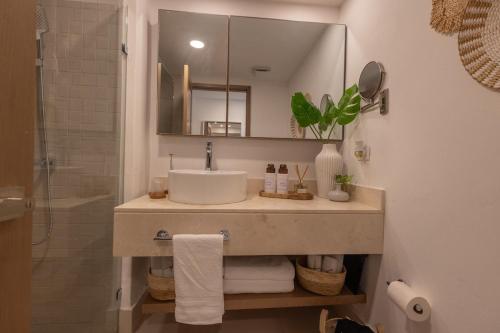 a bathroom with a sink and a mirror and a shower at The beach, my happy place- One bedroom Apartment in Puerto Plata