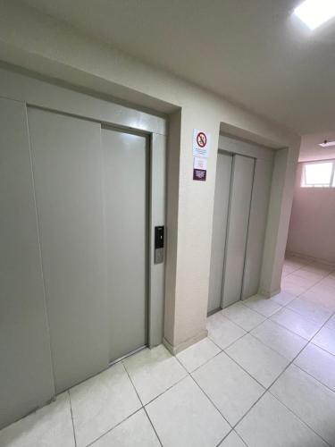 pasillo vacío con 2 puertas y suelo de baldosa en Apto 2 qts em Xerém próximo ao CT do Fluminense, en Duque de Caxias
