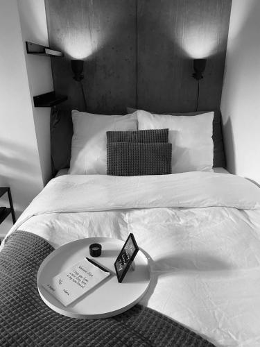 a bed with a tray with a plate on it at Mini feriehus på Aarhus Ø in Aarhus