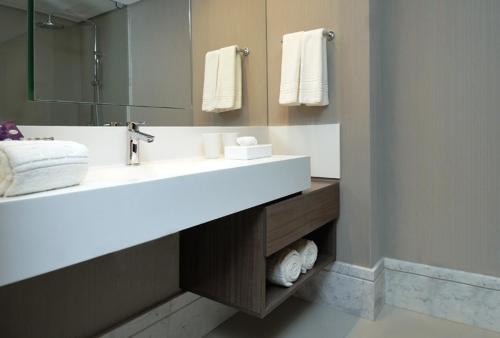 a bathroom with a sink and a mirror and towels at Hotel da Bahia by Wish in Salvador