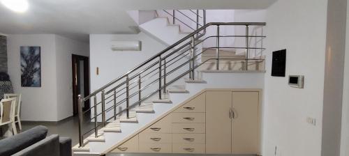 a staircase in a living room with white walls at Villa Doku in Valjiosi