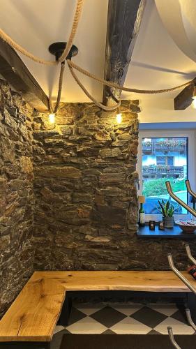 a wooden bench against a stone wall with a window at Alpenfels Zwieselstein in Sölden