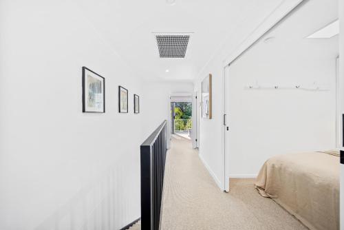 a white room with a bed and a television at Riverbreeze - Close to Hastings 3 bed AC Pool in Noosa Heads