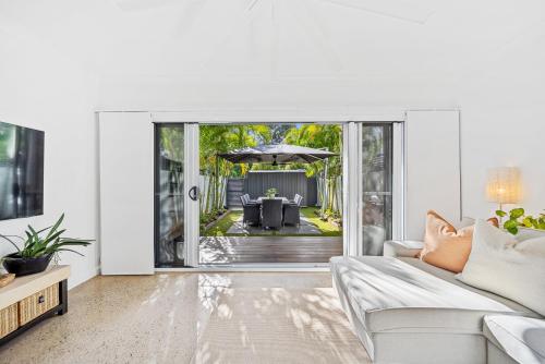 a living room with a couch and an umbrella at Riverbreeze - Close to Hastings 3 bed AC Pool in Noosa Heads