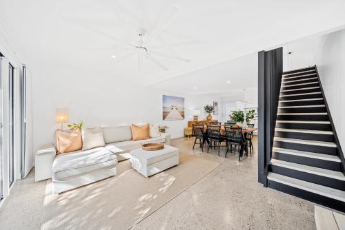 a living room with a white couch and a table at Riverbreeze - Close to Hastings 3 bed AC Pool in Noosa Heads