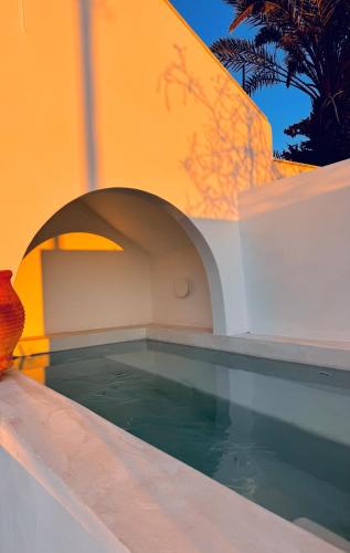 a swimming pool with a vase next to a building at Syrolia Village - Phos in Kinion