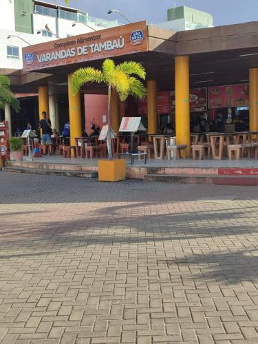 a restaurant with tables and chairs in front of a building at Flat completo 50m da Praia de Tambaú com vista Mar no Terraço e Piscina in João Pessoa
