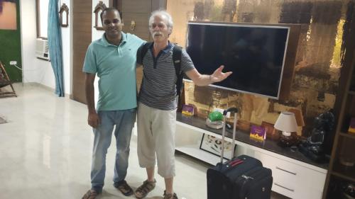 two men standing in front of a tv at The Hideout Agra - Garden Homestay near Taj in Agra