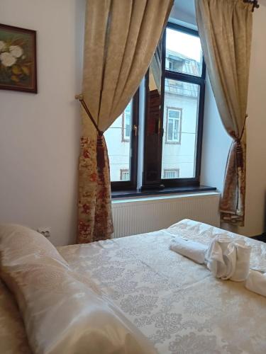 a bedroom with a white bed and a window at Casa Continentelor in Cîmpulung
