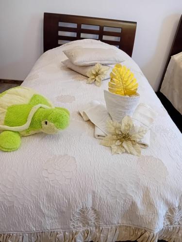 a bed with a green stuffed animal and flowers on it at Casa Continentelor in Cîmpulung