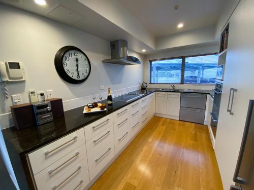 a large kitchen with a large clock on the wall at Oxleys 404 one bedroom with sea views in Picton