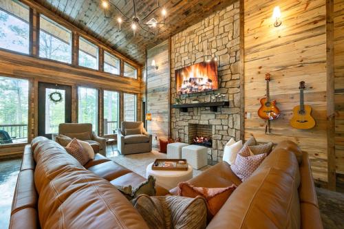 a living room with a large couch and a fireplace at Jam, Swim, Play - Pool, Hot Tub, Ping Pong, Arcade in Broken Bow