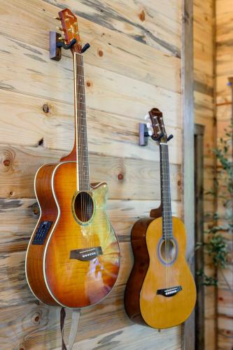 two acoustic guitars hanging on a wall at Jam, Swim, Play - Pool, Hot Tub, Ping Pong, Arcade in Broken Bow