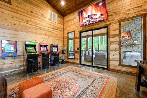 a room with four pinball machines in a log cabin at Jam, Swim, Play - Pool, Hot Tub, Ping Pong, Arcade in Broken Bow