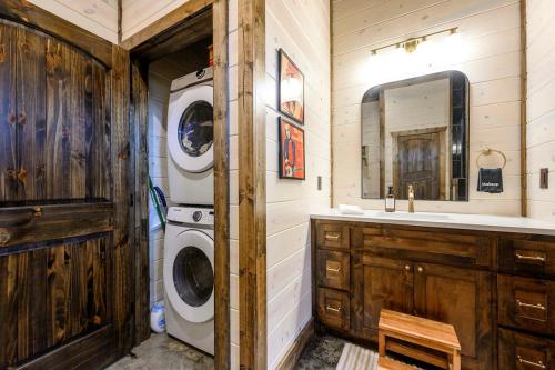 a bathroom with a washing machine and a sink at Jam, Swim, Play - Pool, Hot Tub, Ping Pong, Arcade in Broken Bow