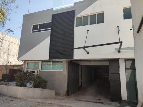 an external view of a building with a garage at Hotel Business in El Gallinero