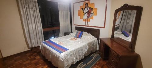 a bedroom with a bed and a mirror and a dresser at City View Apartment La Vista in La Paz