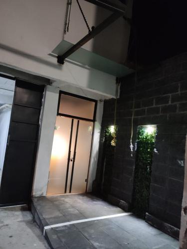 a front door of a building at night at Hotel Business in El Gallinero
