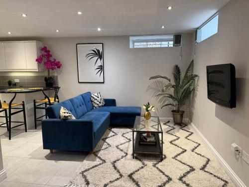 a living room with a blue couch and a table at Central Bury Apartment with Private Entrance in Bury Saint Edmunds
