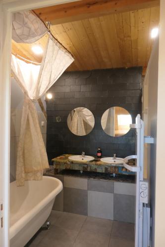 a bathroom with two sinks and a tub and two mirrors at la roche coeur in Vouvray