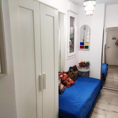 a bed with blue sheets in a room at Sueños del Mediterraneo Estudio in Melicena
