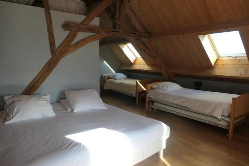 a attic room with two beds and two windows at la roche coeur in Vouvray