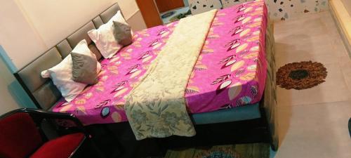 a bed with a pink comforter and pillows at Dev PG Stay in Vrindāvan