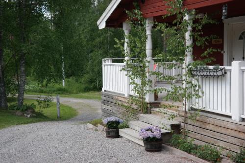 a house with flowers in pots on the side of it at Näsets Marcusgård in Furudal
