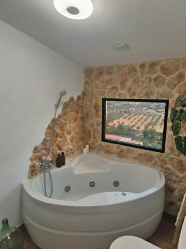 a white bath tub in a bathroom with a window at Casa Rural Abuela Remedios in Segura de León