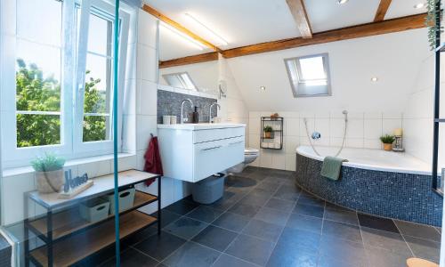 a bathroom with a tub and a toilet and a sink at Ferienhaus Kluser in Oberriet