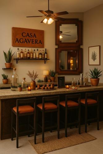 a kitchen with a bar with stools and a mirror at Hotel Hacienda San Pancho in San Francisco